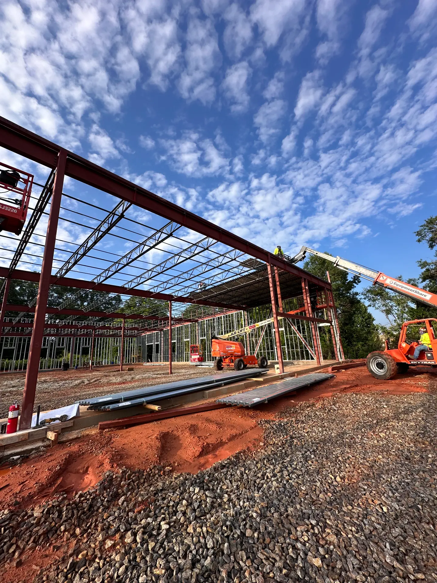 Way2Steel crew erecting a red structural steel frame for a commercial building