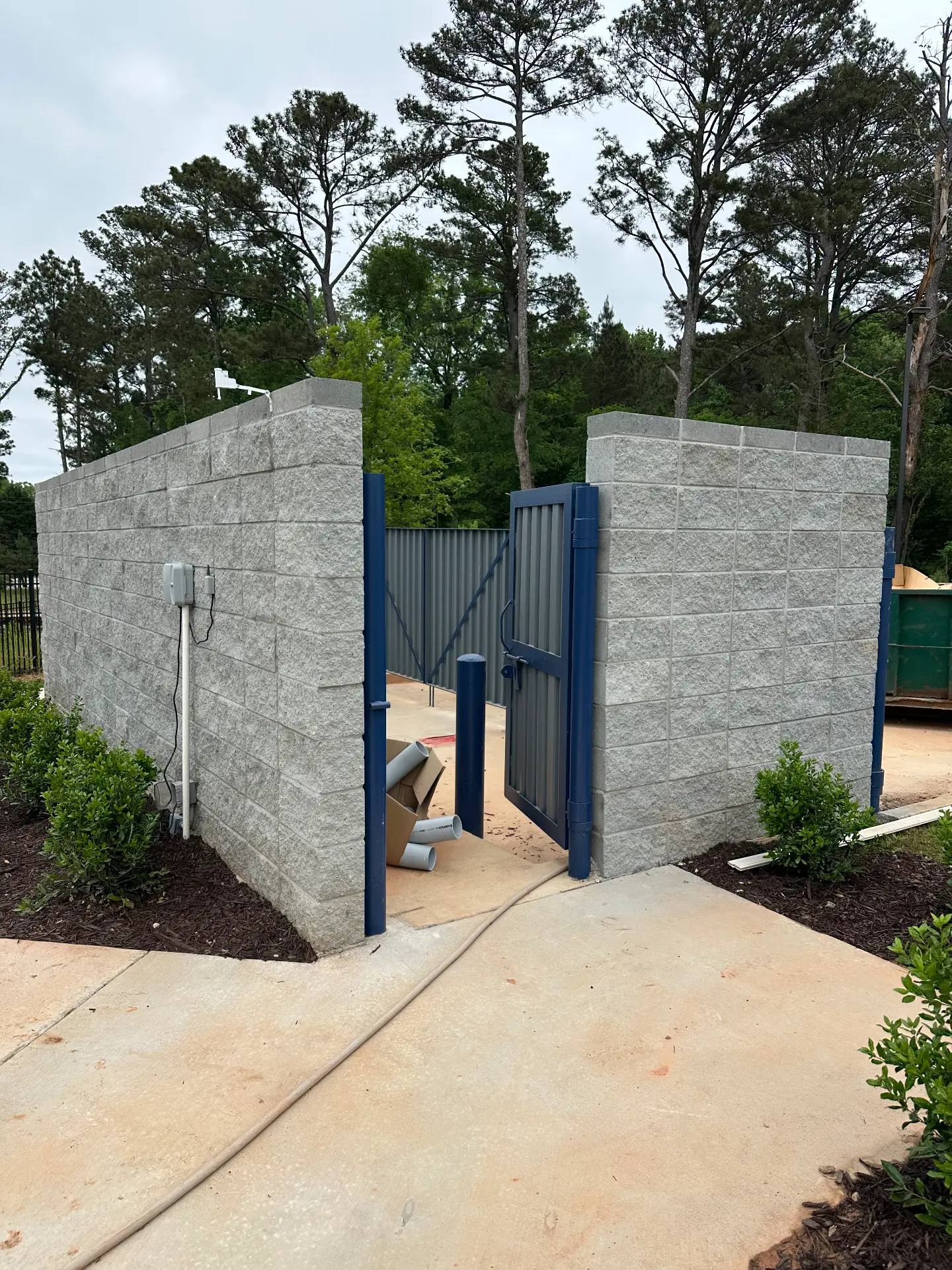 Steel gate and enclosure at a masonry dumpster pad
