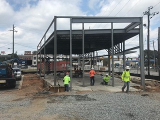 Erection crew with a completed grey steel frame