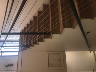 Steel stair with horizontal cable railing and wood treads