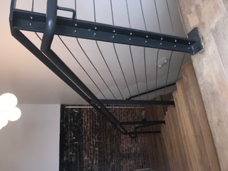 Black steel newel post with horizontal cable railing